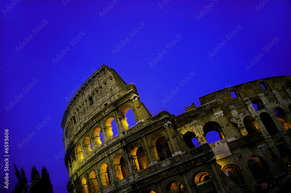 The colosseum  in Rome  at dusk, with blue sky