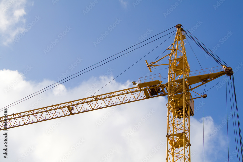 lifting crane under blue sky and white clouds