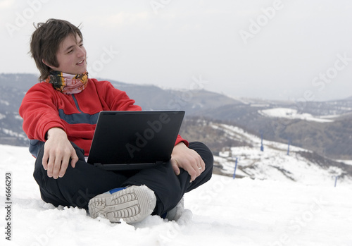 Happy teens student with laptop in hand in winter mountains 