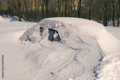 Car covered with snow in winter blizzard snowdrift