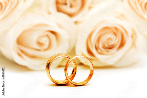 Roses and wedding rings isolated on the white photo