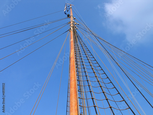 Wooden mast of a boat with clear blue sky behind