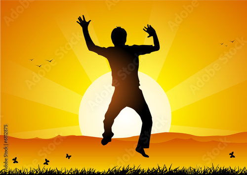 Happy boy jumping at sunset