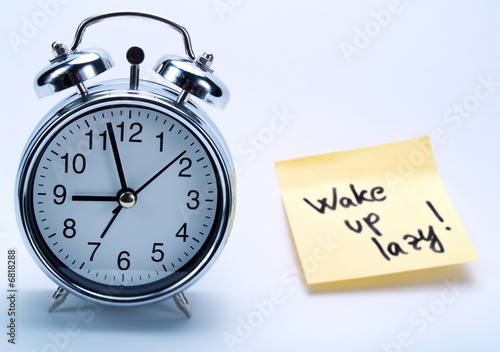 An alarm clock and a yellow note