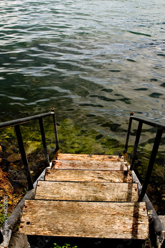 Old grungy stairs leading down to a lake