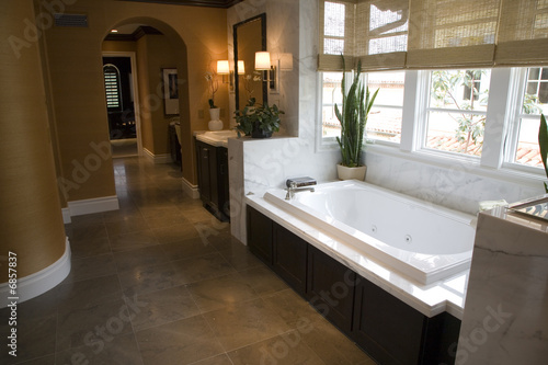 Designer bathroom with a modern tub and tile floor. © Rodenberg