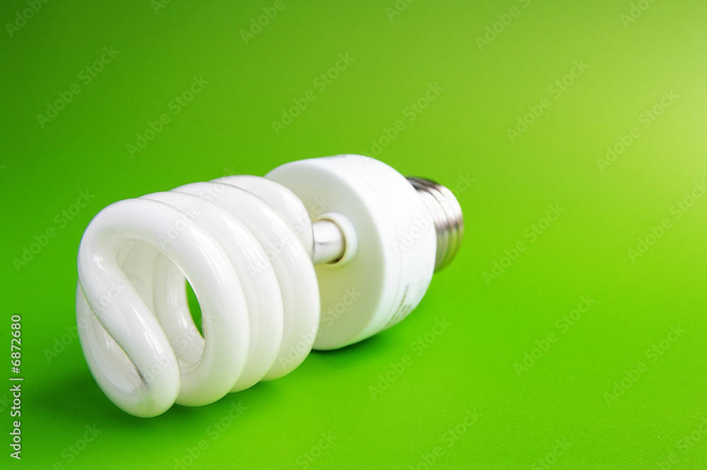 Compact fluorescent light bulb on green (green energy)