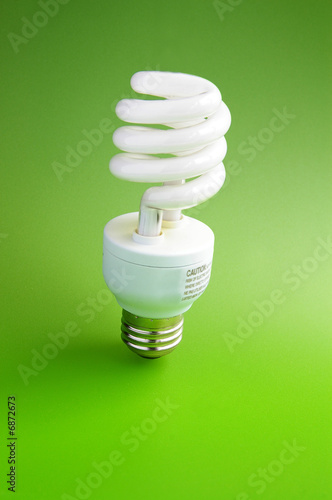 Fluorescent light bulb standing on green background 