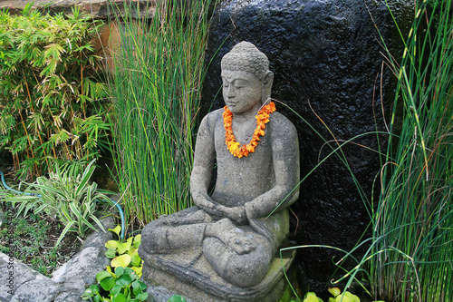 boudha en pierre avec collier