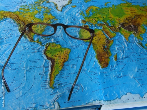 Making a journey plans over the opened atlas and maps