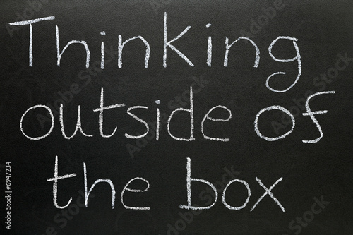 Thinking outside of the box written on a blackboard. photo