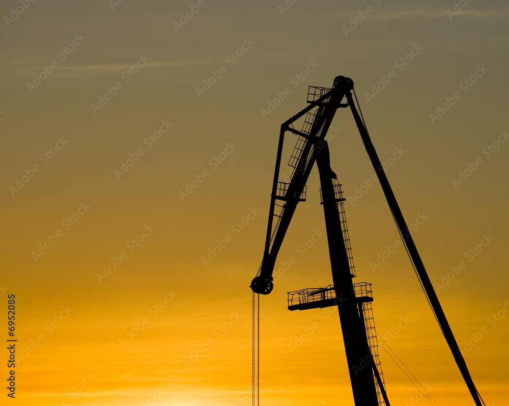 Crane silhouette over sunset sky