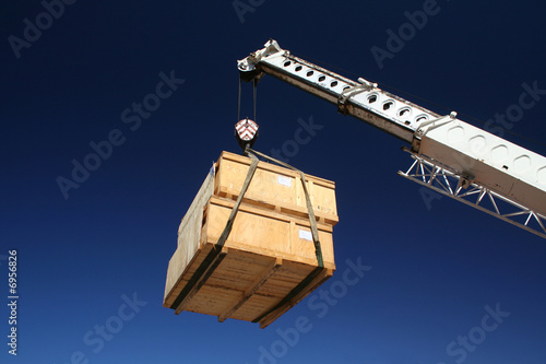 Wooden crates being moved by crane.