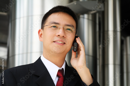 Young asian executive talking on handphone