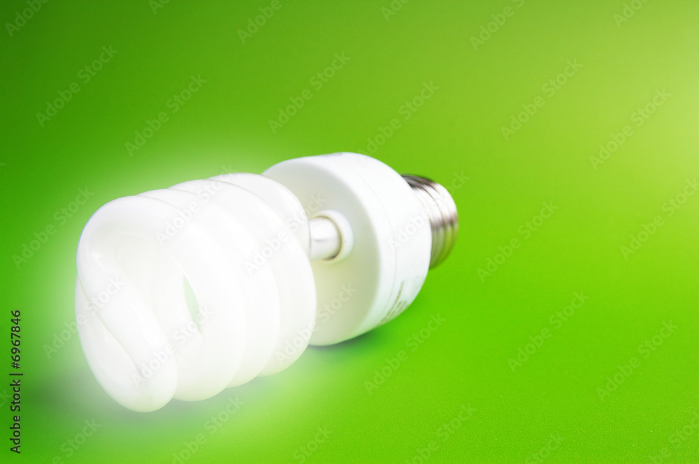 Compact fluorescent light bulb on green (green energy) Compact fluorescent light bulb on green (green energy)