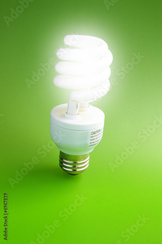 Fluorescent light bulb standing on green background 
