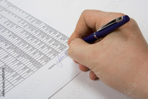Hand signing the document.