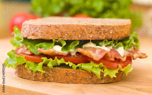 BLT sandwich with fresh veggies in the background