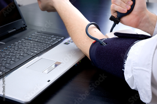 Businessman measuring his blood pressure for himself