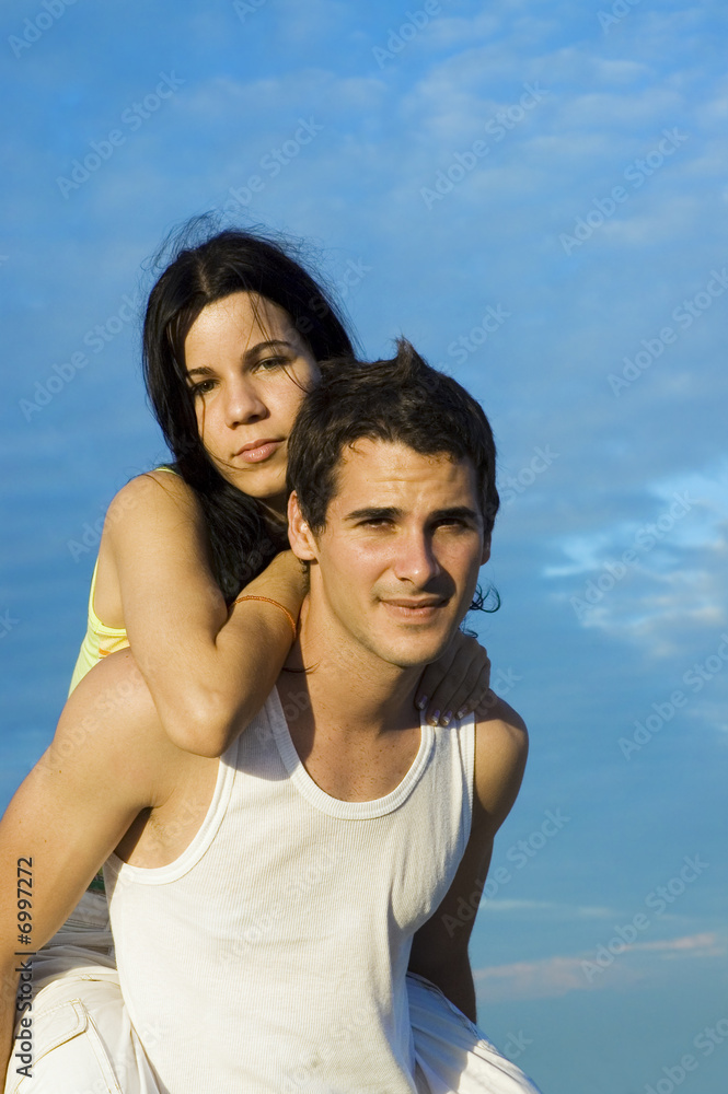 Fototapeta premium Portrait of young hispanic couple in piggyback outdoors
