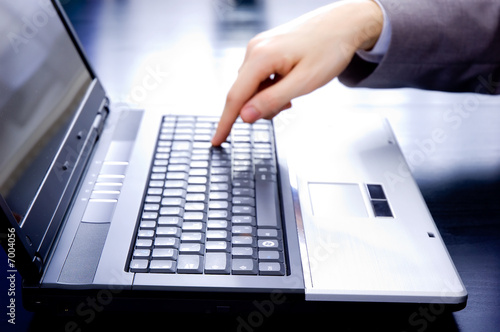 Businessman's out-of-focus hand is pushing the enter button