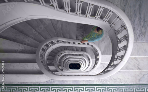 Woman climbing a spiral marble staircase