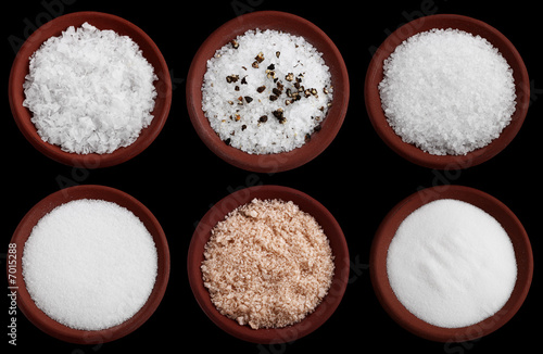 six terracotta plates with different  sea salt on black