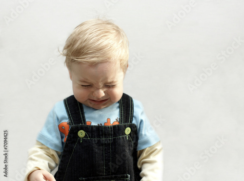 portrait offended small boy on light background