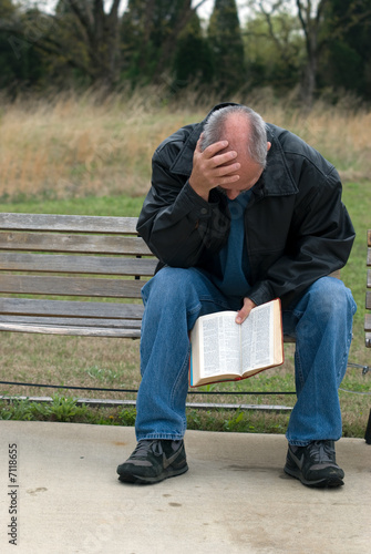 Sad man holding bible