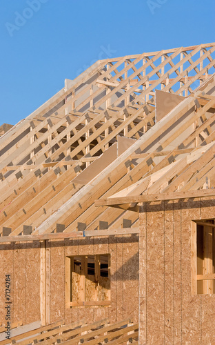 Roof structure of a new home set against clear sky