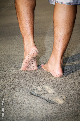 legs of a man walking on the beach