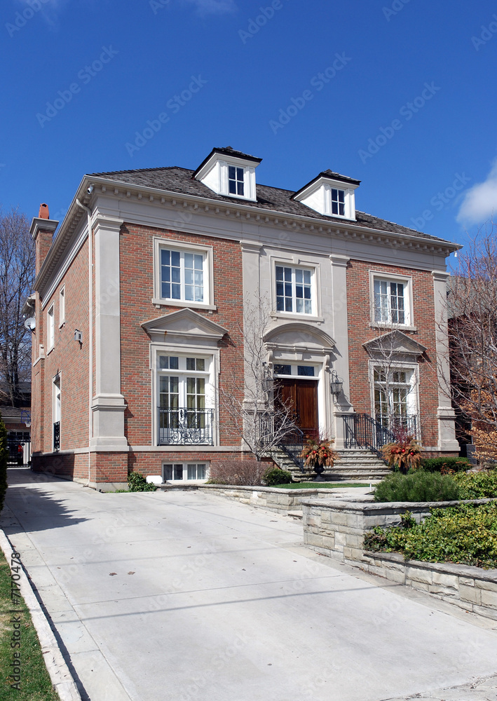 Classical style house with dormers and long driveway