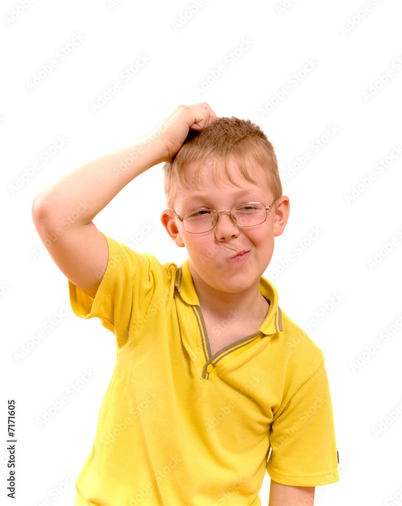 Boy scratches his head in puzzlement or confusion Boy scratches his head in puzzlement or confusion