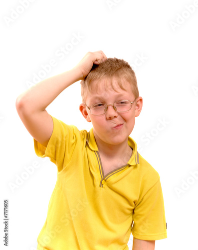 Boy scratches his head in puzzlement or confusion