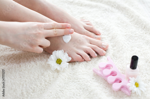 Woman applying cream on her feet