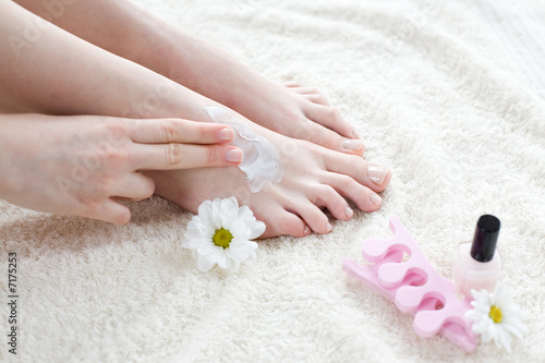 Woman applying cream on her feet