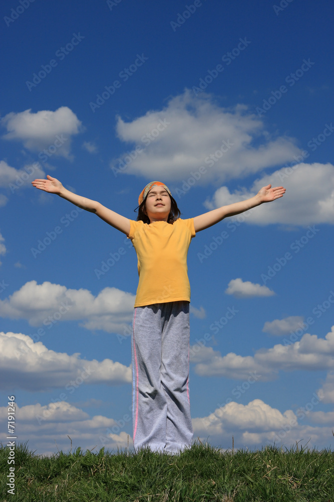 Girl holding hands up against blue sky Girl holding hands up against blue sky