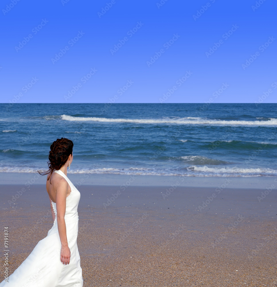 Beautiful woman standing on a beach, looking to the horizon Beautiful woman standing on a beach, looking to the horizon