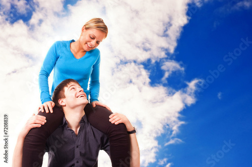 Young couple is having fun (blue sky background)
