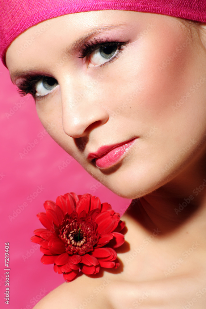 beauty portrait of a young woman in pink with a gerbera