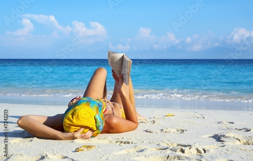 Women is reading on a beach