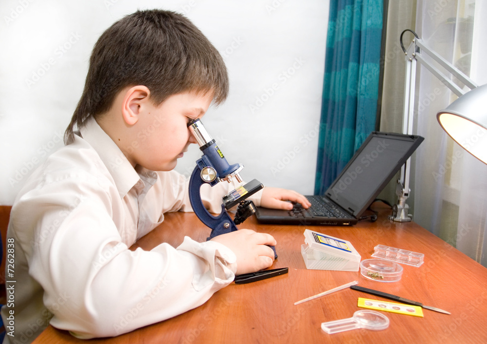 boy with a microscope in the laboratory