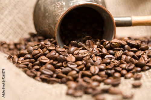 Cezve with freshly roasted coffee beans on sackcloth photo