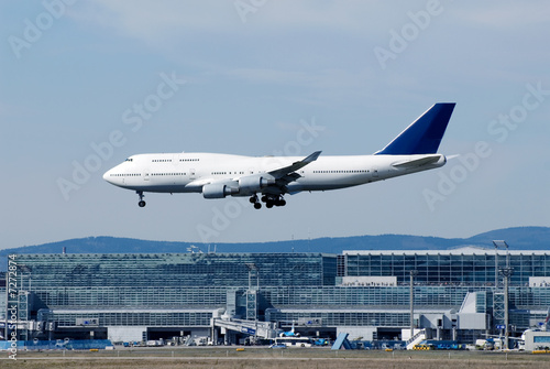 Landendes Flugzeug mit Flughafengebäude 