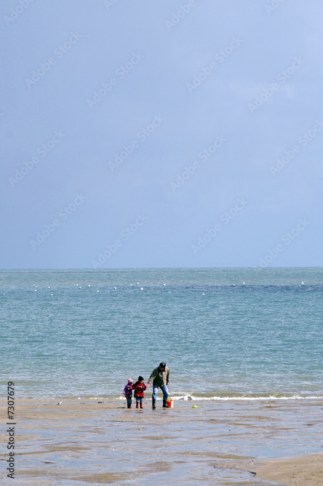 père et ses enfants à la plage