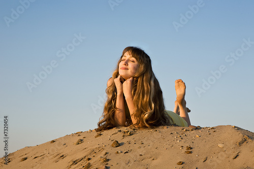 blond girl lying on the beach