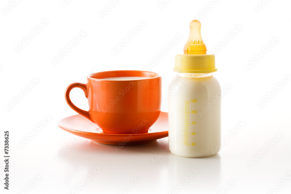 Cup with milk and a bottle with a baby's dummy Cup with milk and a bottle with a baby's dummy