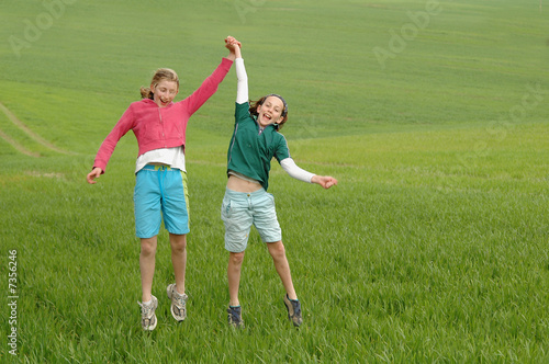 girls jumping in the air in a green field