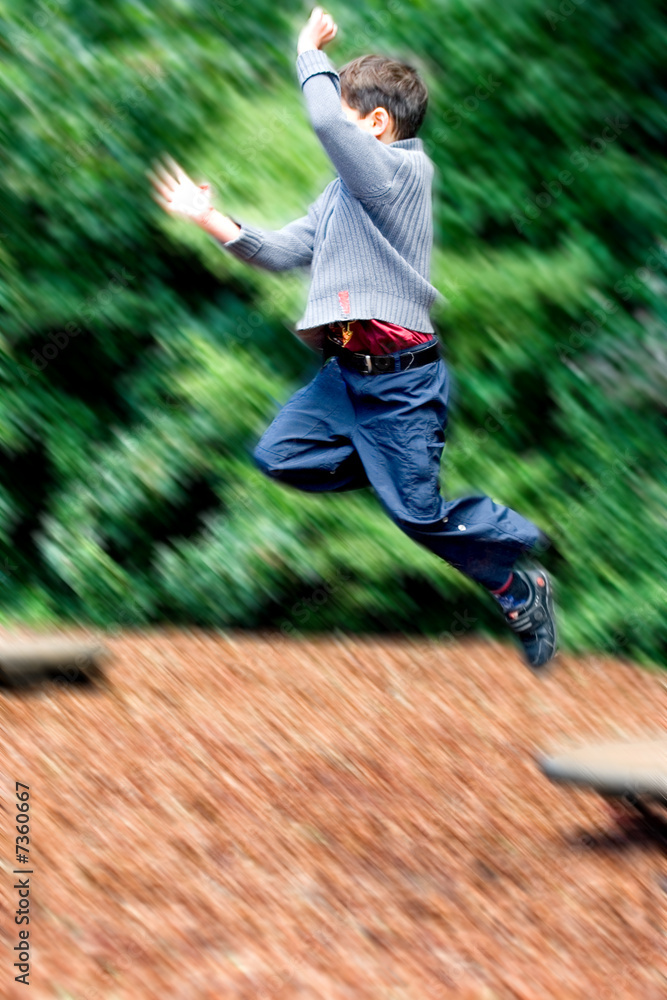 Young boy leaping high in the air, 