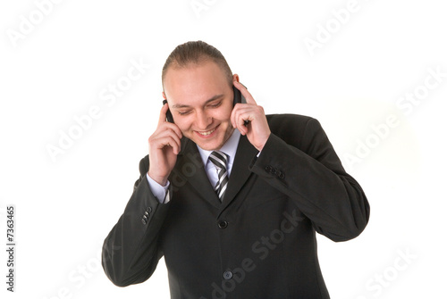 Smiling businessman calling on two phones